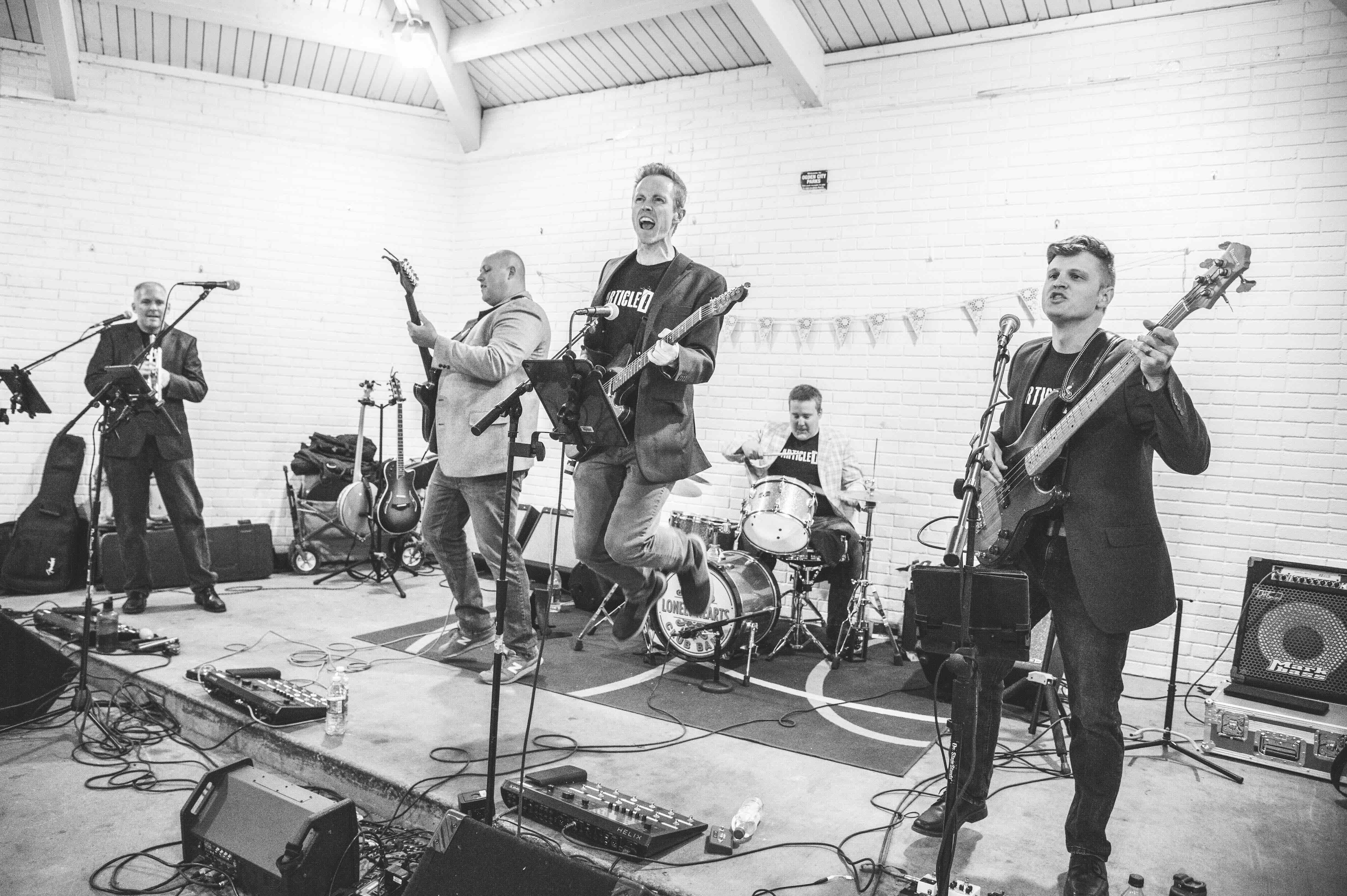 The Civilians rocking out at a wedding gig, Tyler is jumping in the air like a total rockstar